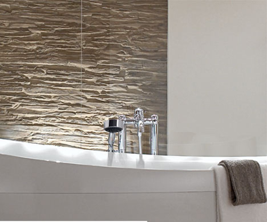 Modern gestaltetes Badezimmer mit freistehender Badewanne und Natursteinwand